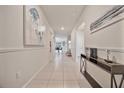 Bright, tiled hallway with decorative art leading to open-concept living spaces, enhancing the home's modern aesthetic at 4149 Lana Ave, Davenport, FL 33897