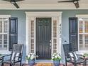 Close-up of a charming front door with black shutters and relaxing seating area at 4533 Burke St, Orlando, FL 32814