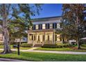 Inviting two-story home with a large front porch, mature trees, and beautifully maintained landscaping at 4533 Burke St, Orlando, FL 32814