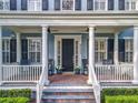 Inviting front porch with brick flooring, comfortable seating, and elegant column details at 4533 Burke St, Orlando, FL 32814
