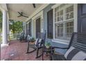 Relaxing front porch with rocking chairs, brick flooring, and views of lush greenery at 4533 Burke St, Orlando, FL 32814