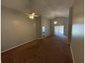 Large living room featuring neutral carpet, paint, ceiling fan, and sliding glass door to the backyard at 5914 Rywood Dr, Orlando, FL 32810