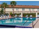 Community pool with lounge chairs and beautiful palm trees that create a serene outdoor living at 600 Northern Way # 404, Winter Springs, FL 32708