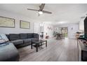 Spacious open-plan living room with modern gray floors, ceiling fan, and view to dining area at 741 Maderia Ct, Kissimmee, FL 34758