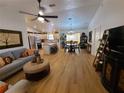 Open-concept living space with wood flooring, neutral color palette, and ample natural light at 1380 Red Ash Pl, The Villages, FL 32162