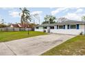 A single story home with blue shutters, a long driveway, and a well-maintained lawn at 1038 E Hancock Dr, Deltona, FL 32725