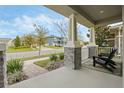 Relaxing front porch view with comfortable seating and decorative columns, perfect for enjoying the neighborhood scenery at 16410 Taliesin St, Winter Garden, FL 34787