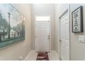 Bright entryway with tile flooring, modern decor and white paneled front door at 17437 Promenade Dr, Clermont, FL 34711