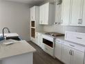 Bright kitchen features white cabinets, stone countertops, and stainless steel appliances at 17505 Glossy Pomelo Way, Winter Garden, FL 34787
