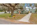 Landscaped front yard of a well-maintained single-Gathering home with sidewalk and mature tree at 201 W 16Th St, Sanford, FL 32771