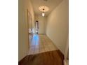 Bright hallway features neutral tile flooring leading to a white paneled front door and a carpeted area at 2952 Ashland S Ln, Kissimmee, FL 34741