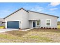 Well-maintained gray one-story home with a blue garage door, matching front door, and neat landscaping at 4016 Sw 151 Street, Ocala, FL 34473