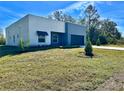 A modern home is surrounded by lush landscaping and features an attached two car garage at 4501 Dallas Blvd, Orlando, FL 32833