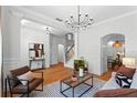 Bright living room featuring wood floors, modern chandelier, and staircase at 5189 Fenwood Ln, Orlando, FL 32814