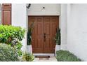 Elegant double front doors framed by lush greenery and potted plants at 5314 Adair Oak Dr, Orlando, FL 32829