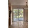 Dining area with tile floors and sliding doors leading to a balcony with outdoor views at 5325 Curry Ford Rd # B201, Orlando, FL 32812