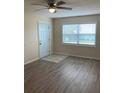 Bright living room with laminate floors, neutral walls, ceiling fan, and a large window at 5325 Curry Ford Rd # B201, Orlando, FL 32812