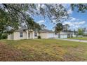 Inviting single-story home with a well-manicured lawn and attached two-car garage, set on a sunny day at 760 Mentmore Cir, Deltona, FL 32738