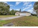 Attractive single-story home with a long driveway leading to an attached garage, surrounded by lush greenery at 760 Mentmore Cir, Deltona, FL 32738