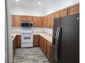 Functional kitchen featuring oak cabinets, modern appliances, and durable flooring at 1004 Travertine Ter, Sanford, FL 32771