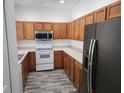 Functional kitchen featuring oak cabinets, modern appliances, and durable flooring at 1004 Travertine Ter, Sanford, FL 32771