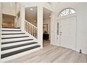 Bright foyer with white walls, light wood floors, staircase and large front door with side window at 1215 Castleport Rd, Winter Garden, FL 34787