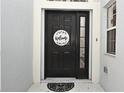 Close up of the black front door with a welcome sign and a small window to the side at 1215 Castleport Rd, Winter Garden, FL 34787