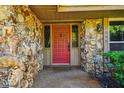 Arched front door with sidelights framed by stonework and a covered entrance to the lovely home at 1606 The Oaks Dr, Maitland, FL 32751