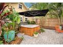 Private backyard oasis featuring a hot tub, lush tropical plants, and cozy seating at 1920 S Palmetto Ave, Sanford, FL 32771