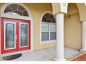 Welcoming front entry with red double doors, white columns, and arched transom windows at 2582 Greenwillow Dr, Orlando, FL 32825