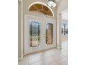 Elegant front doors featuring decorative glass inserts, complemented by neutral tiles and transom window at 2582 Greenwillow Dr, Orlando, FL 32825