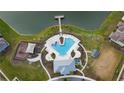 Aerial view of a community pool with a splash pad, playground, dock and recreation areas at 5017 Blue Hammock Ct, Kissimmee, FL 34746