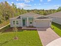 Beautiful home with lush green lawn, brick driveway, and modern architectural details at 5376 Dagenham Dr, Davenport, FL 33837