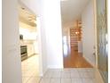 Bright entryway leading to the kitchen and living area with wood floors at 6065 Dory Way, Tavares, FL 32778