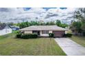 Charming single-story home featuring a well-manicured lawn, attached garage, and mature landscaping at 759 Swallow St, Deltona, FL 32725