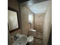 Clean bathroom featuring tile walls and floors, toilet, sink, and shower at 963 26Th Nw St, Winter Haven, FL 33881