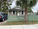 Inviting home featuring a brick facade, tidy lawn, and a lovely decorative picket fence at 2600 Elm Ave, Sanford, FL 32773