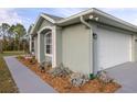Home exterior displaying architectural detail, garden beds, and a paved walkway at 1045 S State Road 415, New Smyrna Beach, FL 32168