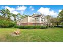 Exterior view of building with well-manicured lawn and bench at 13013 Mulberry Park Dr # 222, Orlando, FL 32821