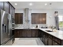 Modern kitchen with stainless steel appliances, dark wood cabinets and designer backsplash at 14384 Alafaya Oak Bnd, Orlando, FL 32828