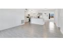 Open living space with new tile floors, seamlessly connecting the living area to the kitchen at 1612 Idaho Ave, Belle Isle, FL 32809