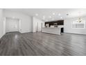Bright, open-concept living space with gray floors flowing into kitchen featuring a central island at 1760 Astrid Rd, Davenport, FL 33837