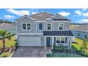 Beautiful two-story home features gray siding, attached garage, and a cozy front porch at 1795 Nw 44Th Ct Rd, Ocala, FL 34482