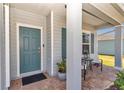 A covered front porch offers a cozy spot, complete with seating, brick floors, and a blue door at 1795 Nw 44Th Ct Rd, Ocala, FL 34482
