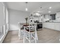 Dining area with a table and a view into the kitchen, featuring modern white cabinets at 1838 Warringwood Dr # B-3, Orlando, FL 32839