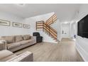 Spacious living room featuring wood-look flooring, a staircase, and contemporary decor at 1838 Warringwood Dr # B-3, Orlando, FL 32839
