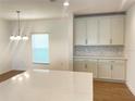 Well-lit kitchen with a spacious quartz countertop island and white cabinetry at 2202 Bass Catcher Dr, Davenport, FL 33837