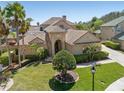 Beautiful home with a well-manicured lawn, mature palm trees, and a tile roof, creating an inviting curb appeal at 2368 Buckingham Run Ct, Orlando, FL 32828