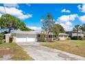 Inviting single-story home featuring a two car garage and mature trees at 2613 Nela Ave, Belle Isle, FL 32809