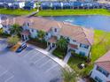 Aerial view of townhome complex with water view, lush landscaping, and ample parking at 4841 Romeo Cir, Kissimmee, FL 34746